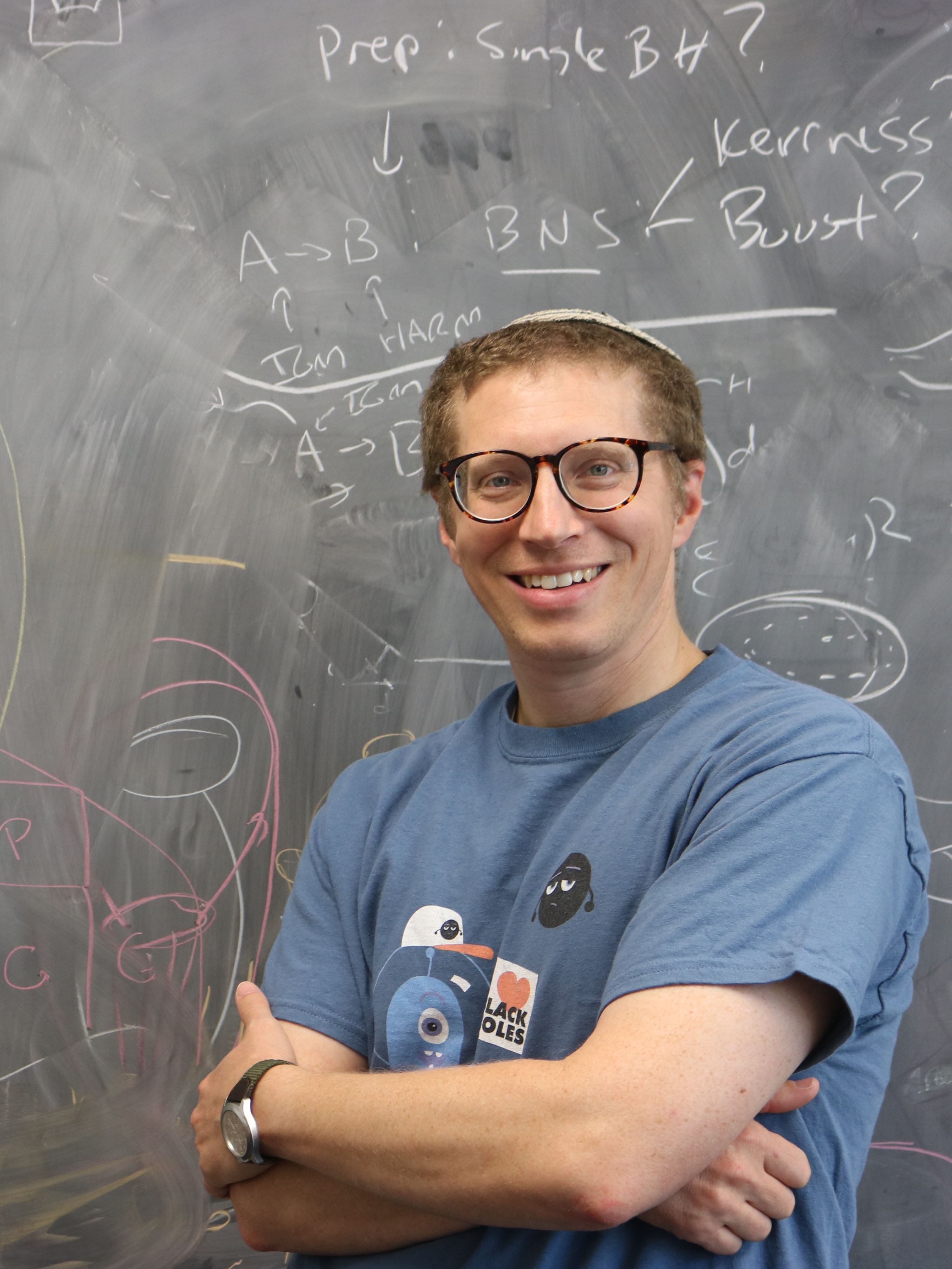 Jeremy smiling in
        front of a blackboard